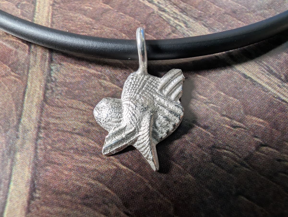 A silver pendant made of ossa sepia and shells via sand casting