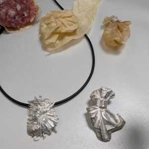 Sausage, its skin and pendants of silver based on it